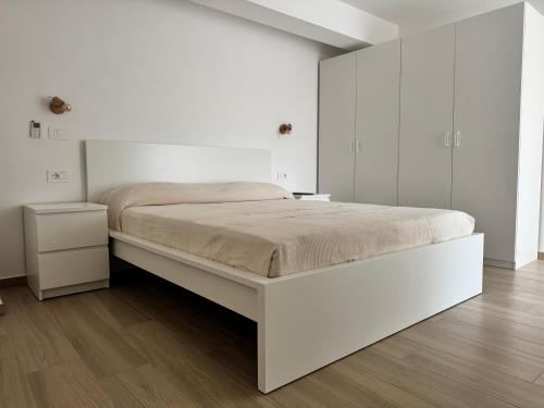 Un dormitorio blanco con una gran cama blanca. en Casa Buono Holidays, en Isquia