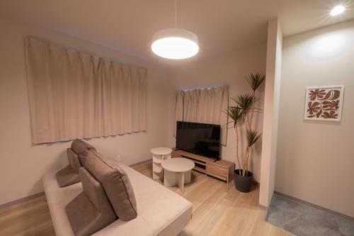 a living room with a couch and a tv at ほうしんノマ HOUSHIN noma in Osaka