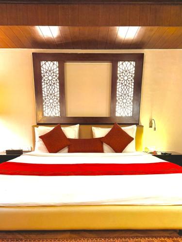 a bedroom with a large bed with red and white pillows at The Vintage Gulmarg in Gulmarg