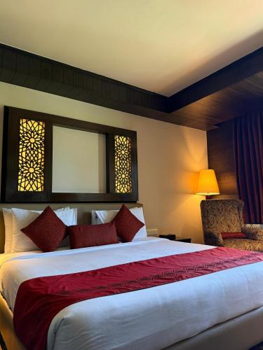 a bedroom with a large white bed with red pillows at The Vintage Gulmarg in Gulmarg