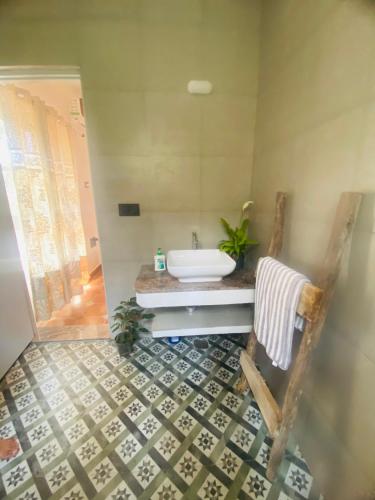 a bathroom with a tub and a sink and a chair at Studio Apartment jungle view 2minutes drive to the beach in Colva