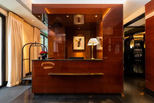 a living room with a mirror and a table at Hotel Montaigne in Paris