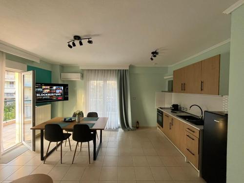 a kitchen with a table and chairs in a room at Odyssey Mare Steps from the Sea in Perea