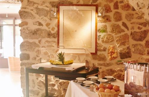 a table with a mirror on a stone wall at Welcome Hotel in Villefranche-sur-Mer