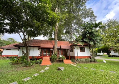 a house with a red roof and some trees at Supalai Pasak Resort Hotel And Spa in Kaeng Khoi
