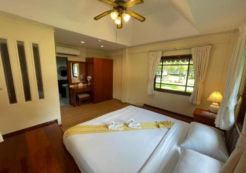 a bedroom with a large white bed and a window at Supalai Pasak Resort Hotel And Spa in Kaeng Khoi