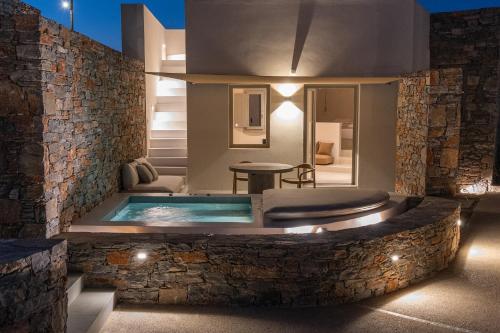 a pool in a house with a stone wall at Pentanemi Folegandros in Ano Meria