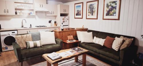 a living room with two couches and a table at Little Para Cottage Tanunda in Tanunda