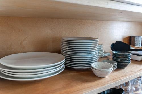 a shelf with white plates and bowls on it at King Deer in Higashikawa