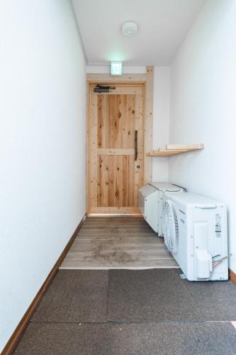 a laundry room with a washer and dryer and a door at King Deer in Higashikawa