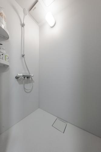 a white bathroom with a shower and a sink at King Deer in Higashikawa