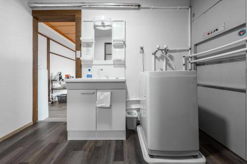 a white kitchen with a sink and a stove at King Deer in Higashikawa