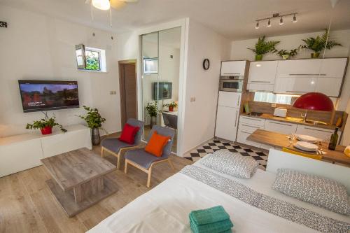 a living room with a bed and two chairs at Apartments Gardelin Superior in Zadar