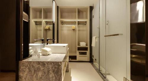 a bathroom with a sink and a large mirror at Echarm Hotel Guizhou Xingyi Jushan Avenue in Xiawutun