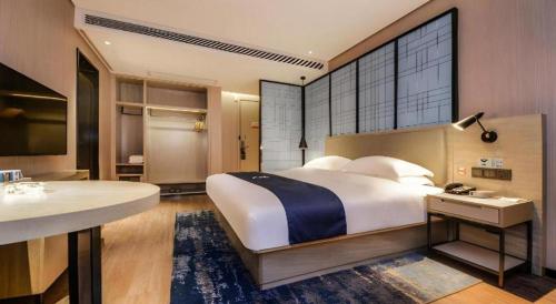a bedroom with a large bed and a bathroom at Echarm Hotel Guizhou Xingyi Jushan Avenue in Xiawutun