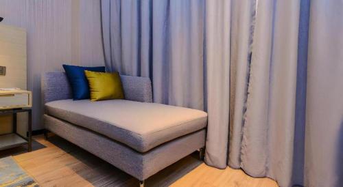 a chair sitting in front of a window with curtains at Echarm Hotel Guizhou Xingyi Jushan Avenue in Xiawutun
