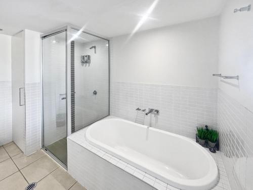 Nelly BayにあるBlue on Blue Superior Studio Room 1271の浴槽とシャワー付きの白いバスルーム