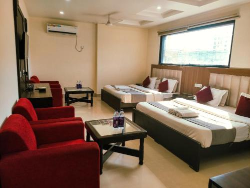 a hotel room with two beds and a couch and a chair at Hotel AG Royal Affordable Blissful Stay in Haridwār