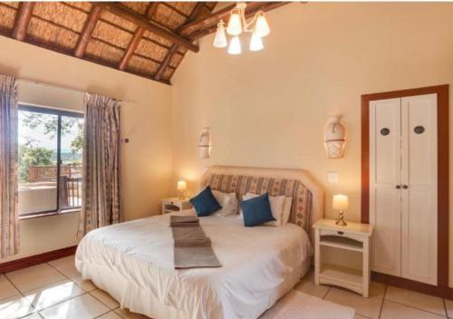 a bedroom with a large bed and a window at 205 Zebula, 4 bedroom house in Warmbaths