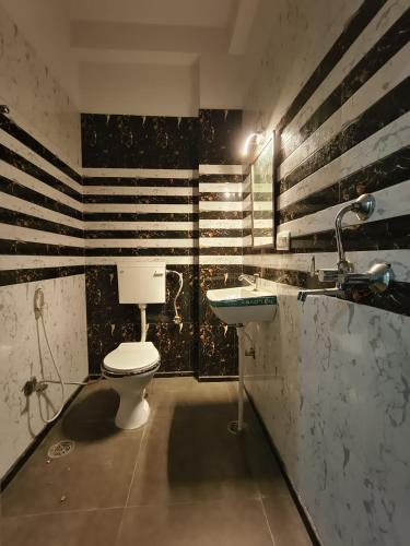 a bathroom with a toilet and a sink at After House South Opulent 5BHK Pool Mansion in Jaipur