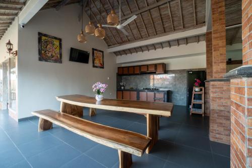 a wooden table and bench in a room at Sundari Bali Guest House in Munggu
