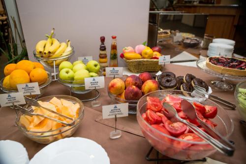 a table topped with bowls of fruits and vegetables at Hemus Hotel Sofia in Sofia