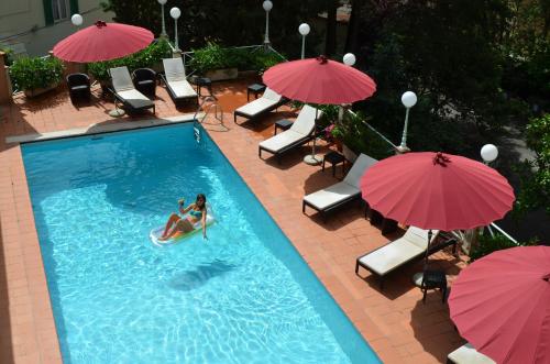 una donna che cavalca una tavola da paddle in una piscina con ombrelloni di Grand Hotel Nizza Et Suisse a Montecatini Terme