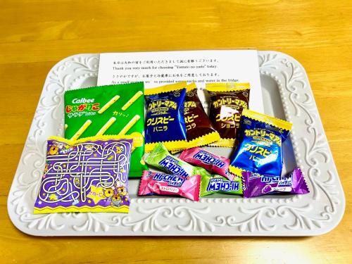 a white plate with some snacks on a table at 大和の宿 Kitabukuro201 in Nara
