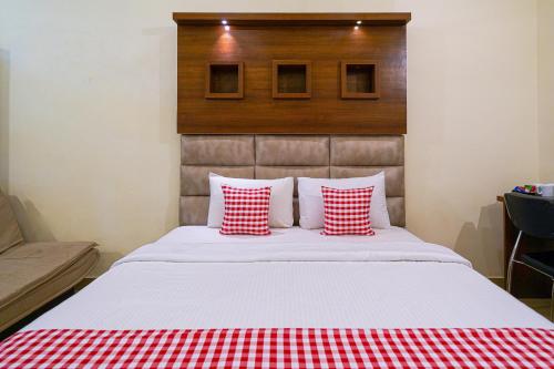 a bedroom with a bed with red and white pillows at Open Hotel by Olive - Biranji Aqua Reatreat in Chikmagalūr