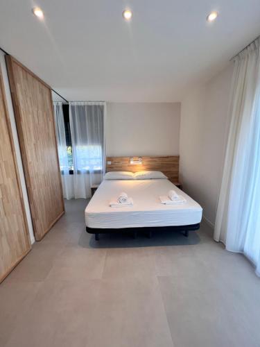 a bedroom with a large white bed in a room at Camping Joncar Mar in Roses