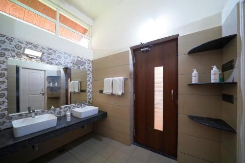 a bathroom with two sinks and a mirror at Open Hotel by Olive - Biranji Aqua Reatreat in Chikmagalūr
