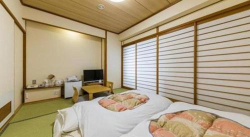 a bedroom with a bed in a room with windows at Sunroute Aomori Hotel in Aomori