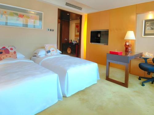 a hotel room with two beds and a desk at Radegast Hotel CBD in Beijing