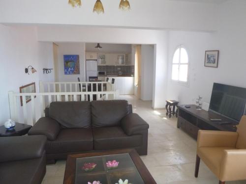 a living room with a couch and a tv at Paradisos House in Skiathos