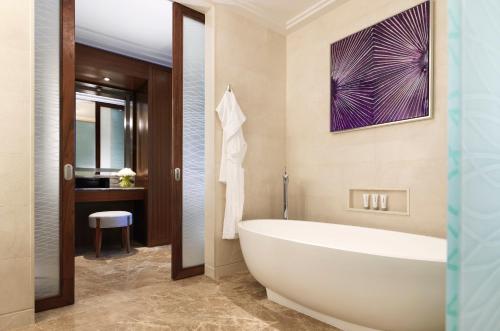 a bathroom with a white tub and a sink at Four Seasons Hotel Abu Dhabi at Al Maryah Island in Abu Dhabi