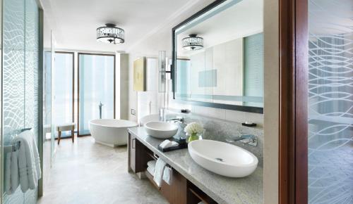 a bathroom with two sinks and a large mirror at Four Seasons Hotel Abu Dhabi at Al Maryah Island in Abu Dhabi