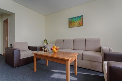 a living room with a couch and a table with fruit on it at Hemus Hotel Sofia in Sofia