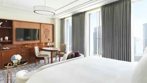 a hotel room with a large bed and a living room at Four Seasons Hotel Abu Dhabi at Al Maryah Island in Abu Dhabi