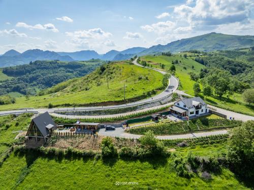 an aerial view of a house on a hill with a road at Cabana Brad Apuseni in Rîmeţi