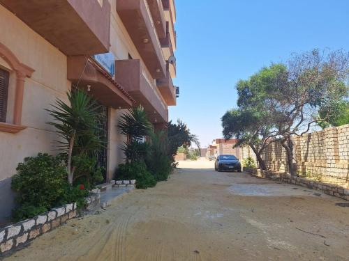 a car parked on a street next to a building at بيت العز للشقق الفندقية - علم الروم Bet Elezz Apartments-Alam Elrom in Marsa Matruh