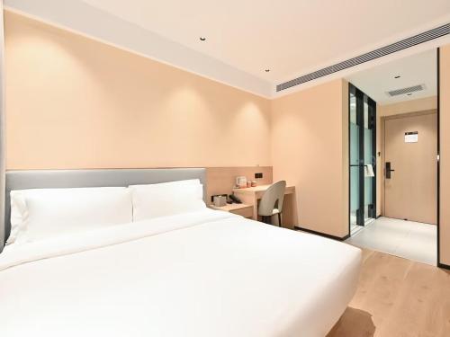 a bedroom with a white bed and a desk at CJIA APARTHOTEL Beijing Sanyuanqiao in Beijing