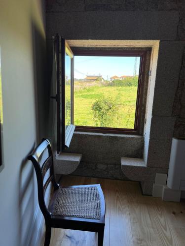 a room with a chair and a window with a view at Maia dos Reis Hotel Rural in Maia