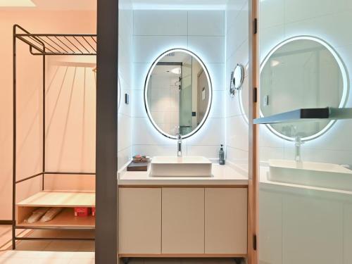 a bathroom with a sink and a mirror at CJIA APARTHOTEL Beijing Sanyuanqiao in Beijing