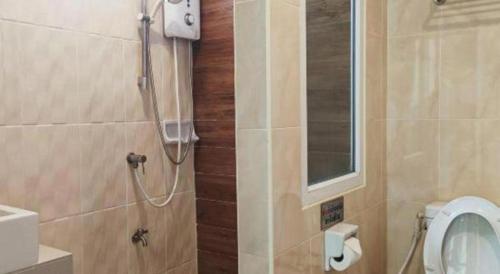a bathroom with a shower with a toilet and a mirror at Mon Muang Hotel in Chiang Mai