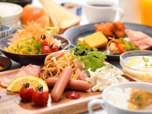 a table with plates of food on a table at La'gent Inn Kesennuma in Higashi-hachimammae