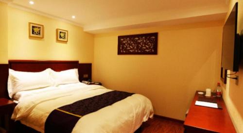 a hotel room with a bed and a desk at GreenTree Inn Xian Longshouyuan Subway Station Business Hotel in Xi'an
