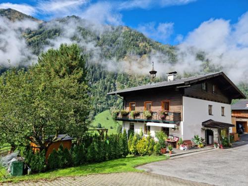 a house with a mountain in the background at Kleintierhof Seidl-Eder in Rauris