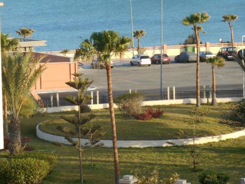 a view of a parking lot with palm trees and the ocean at Boutique Hôtel Albaraka in Dakhla