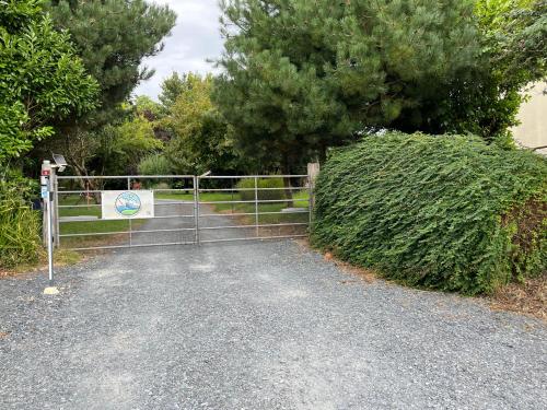 a gate with a sign on the side of a road at Chambre à la campagne la ch tite bauquerie in Commes