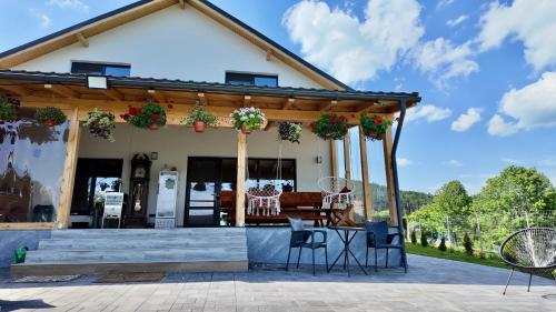a house with a pergola and a table and chairs at Cabana Brad Apuseni in Rîmeţi